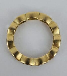 Gold circular object with segmented design.