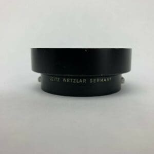 Black Leitz lens adapter on white background.