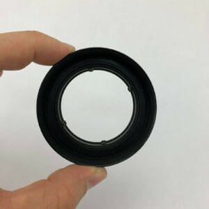 Hand holding a small black camera lens.