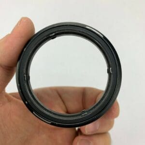 Hand holding a circular camera lens adapter.