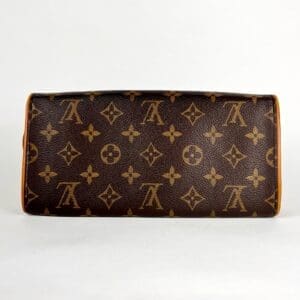 Brown designer clutch with monogram pattern.