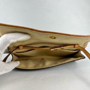 Open beige handbag with leather trim.