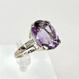 Silver ring with large purple gemstone.