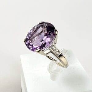 Silver ring with large purple gemstone.