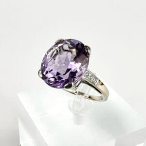 Silver ring with large purple gemstone.