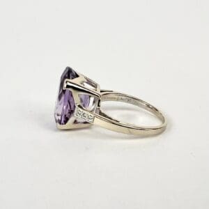 Silver ring with purple gemstone side view.