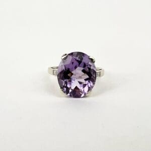 Silver ring with large purple gemstone.