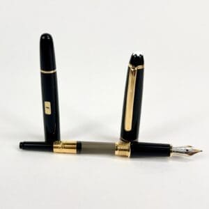 Black and gold fountain pen with cap.