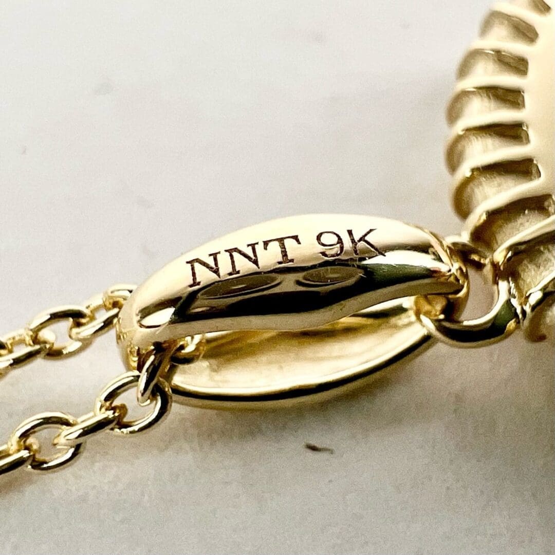Gold chain with "NNT 9K" engraving.