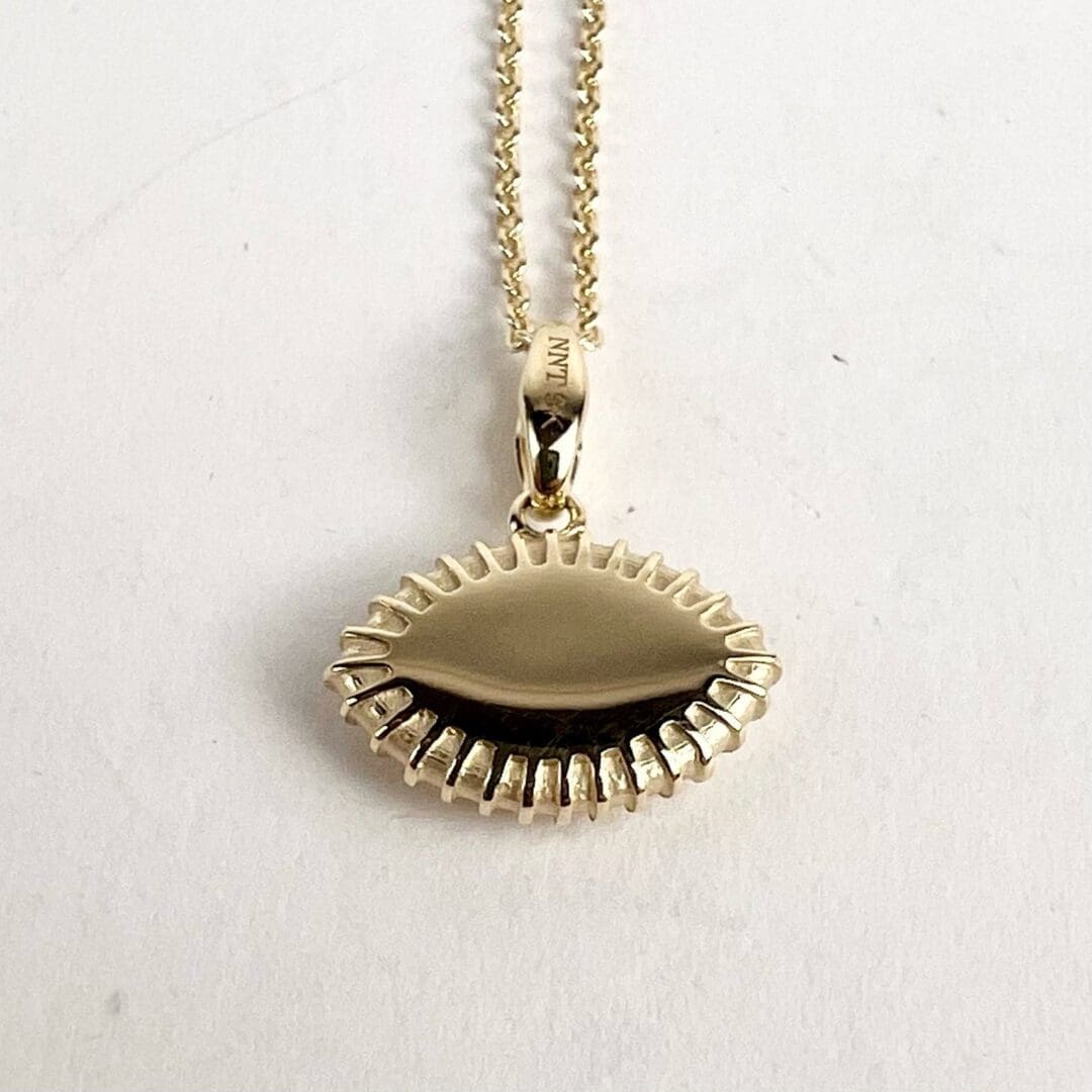 Gold pendant necklace on white background.