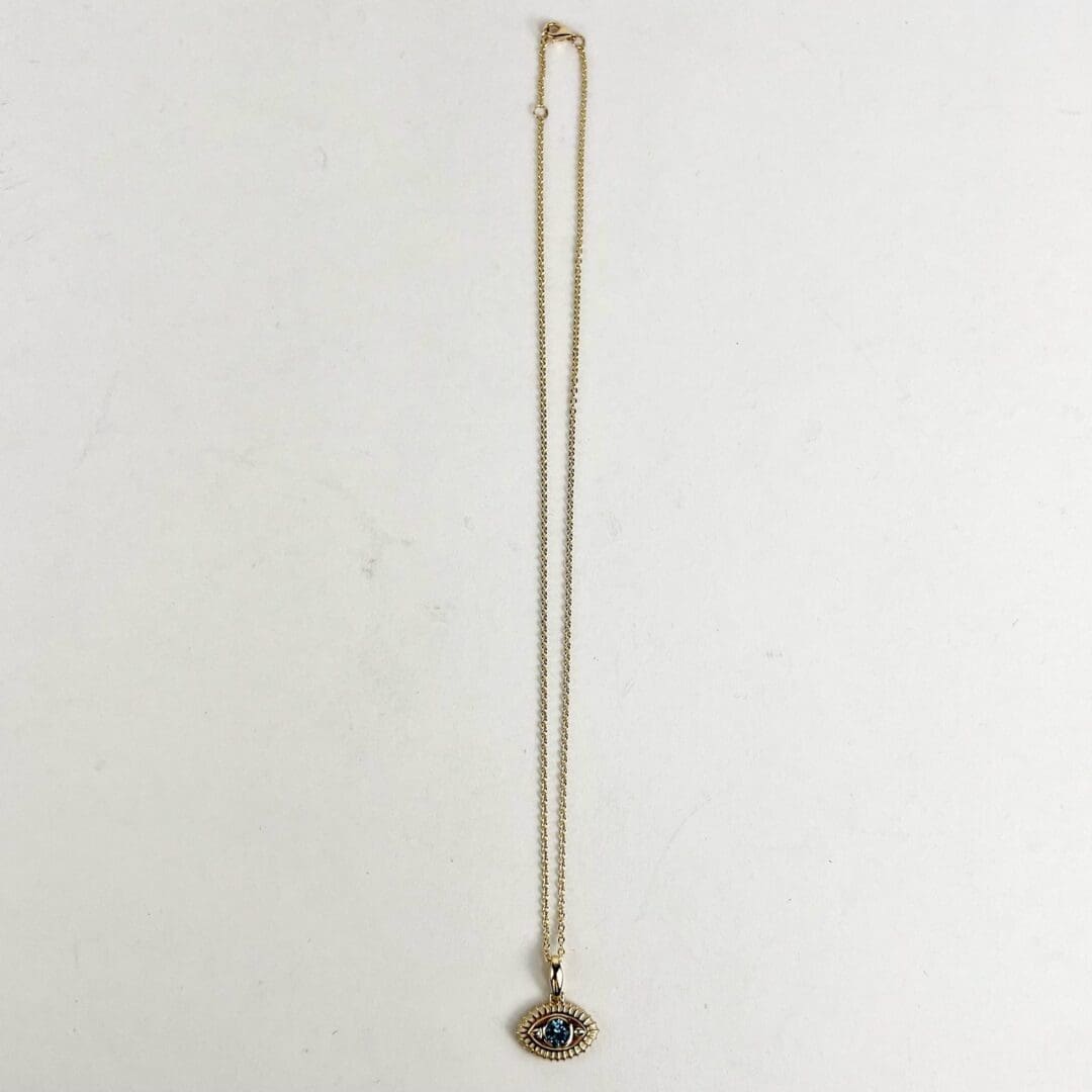 Gold necklace with eye-shaped pendant.