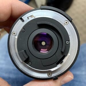 Camera lens held in hand, rear view.