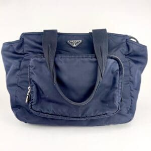Blue handbag with front pocket and handles.