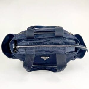 Dark blue handbag with multiple zippers.