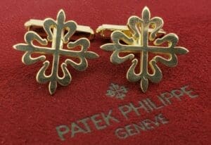 Gold cufflinks on red Patek Philippe box.
