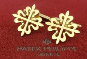 Gold cufflinks on red Patek Philippe box.