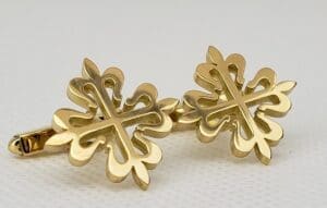 Gold cufflinks with floral cross design.