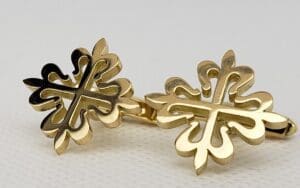 Gold cufflinks with decorative cross pattern.