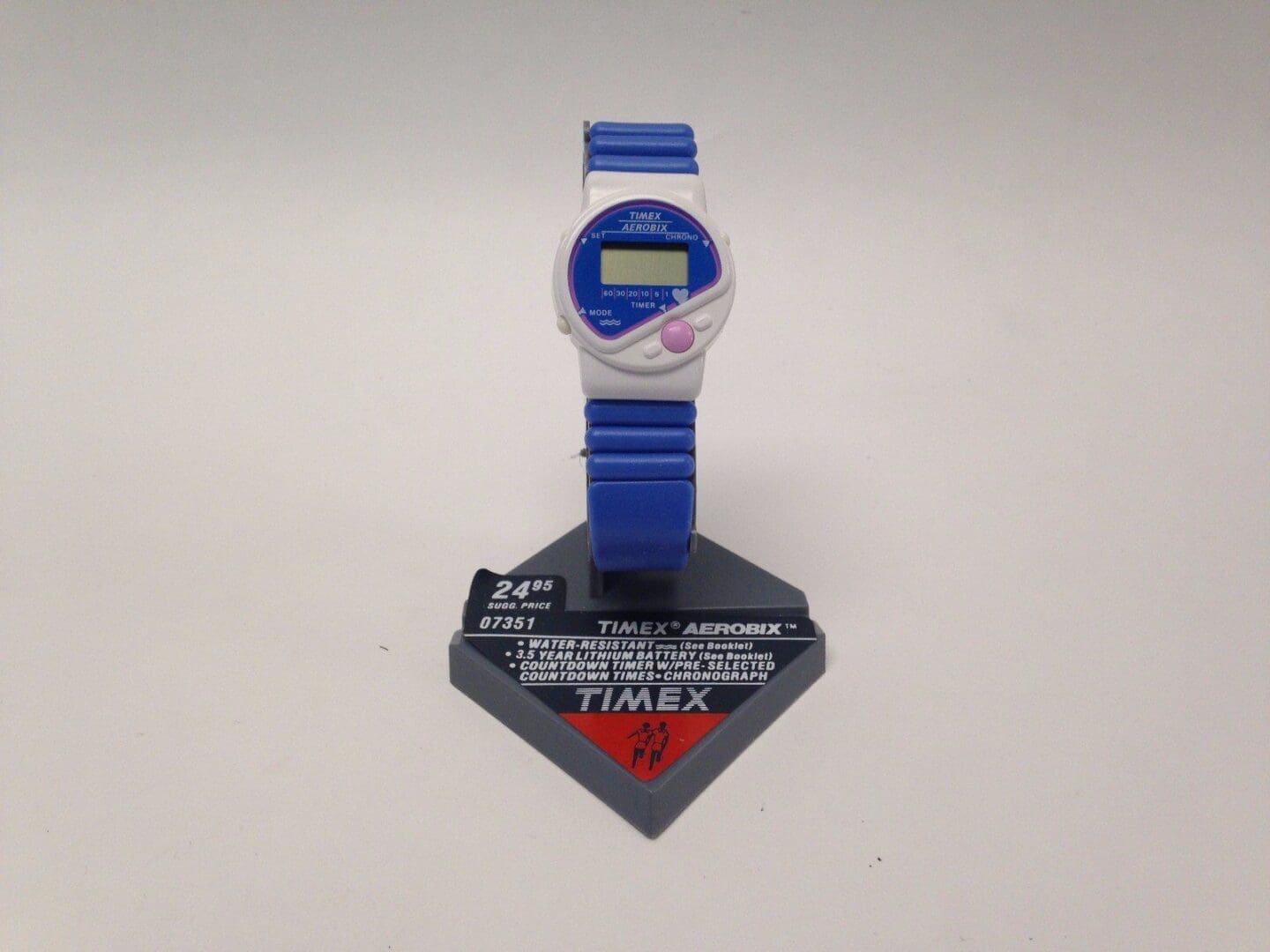 Blue Timex digital wristwatch on display stand.