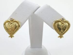 Gold heart-shaped earrings with angel design.
