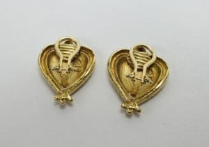 Gold heart-shaped earrings on white background.