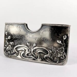 Silver card holder with floral engravings.