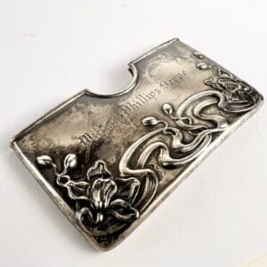 Ornate silver card holder with floral design.