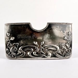 Silver card holder with floral design engraving.