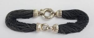 Black braided bracelet with silver clasps.