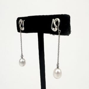 Silver chain earrings with pearl drops.