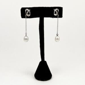Silver chain earrings with pearl drops.