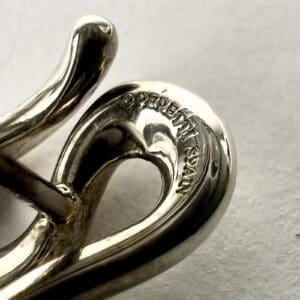 Silver jewelry piece with engraved text.