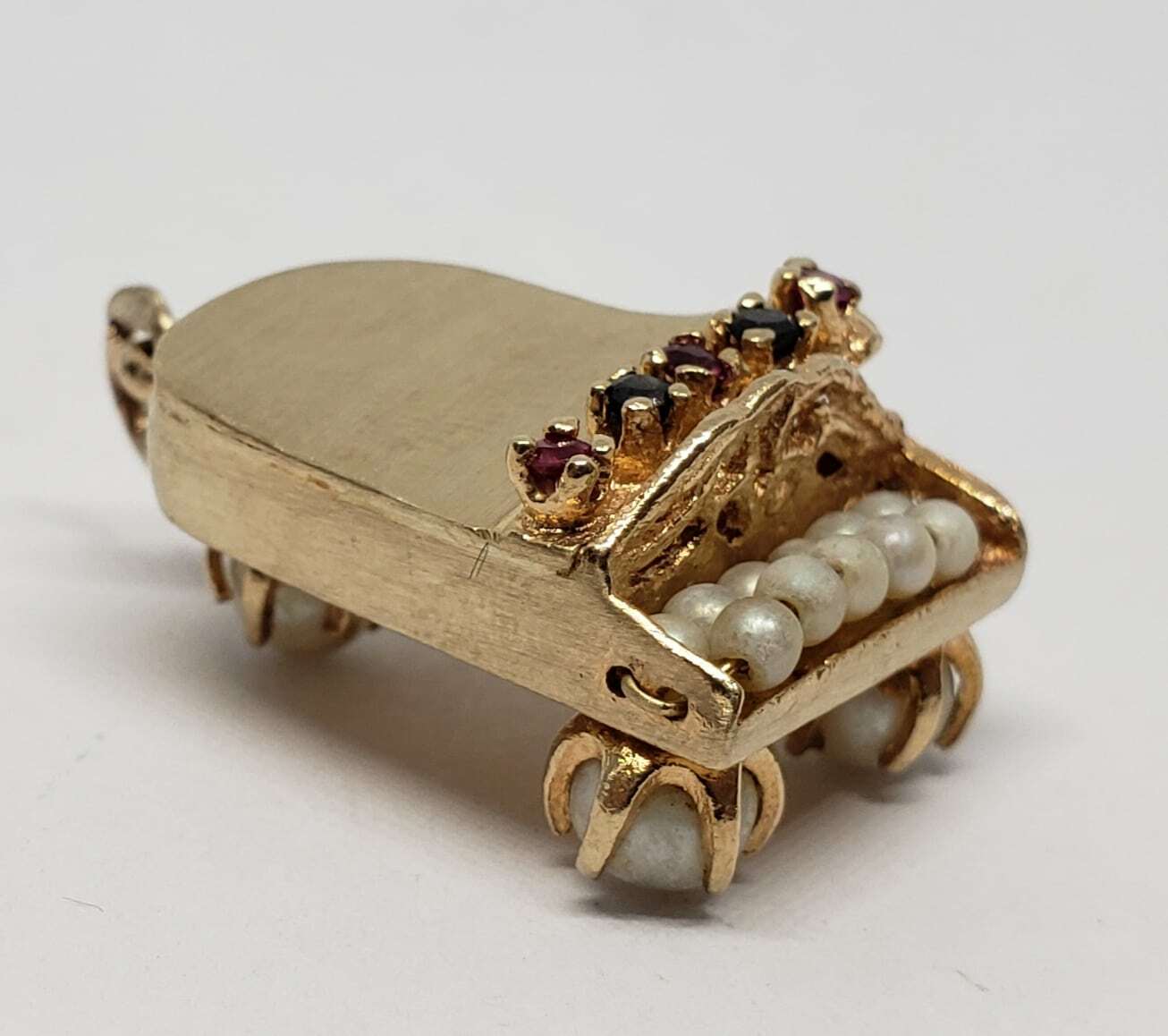Miniature gold piano with pearl keys.