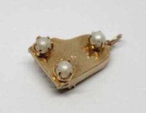 Gold pendant with three white pearls.
