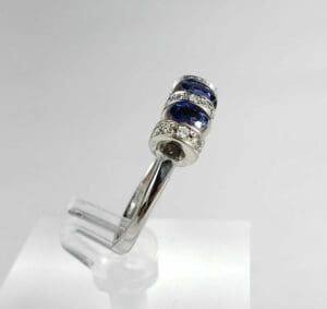 Silver ring with blue gemstones and diamonds.
