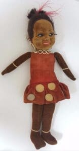 Vintage doll with red dress and necklace.
