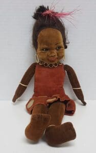 Vintage doll with red dress and necklace.