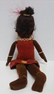 Back view of a seated cloth doll.