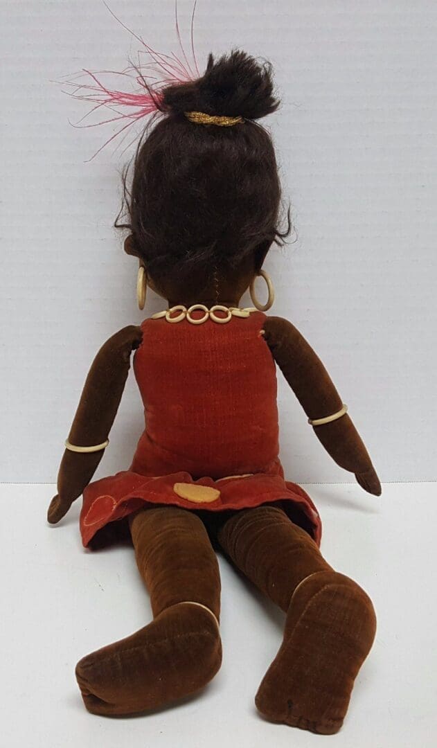 Back view of a seated cloth doll.