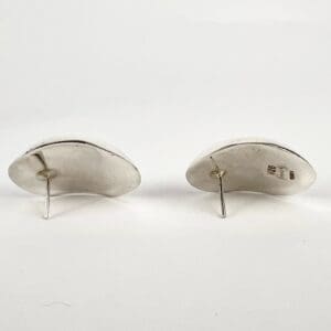 Silver earrings with posts on display.