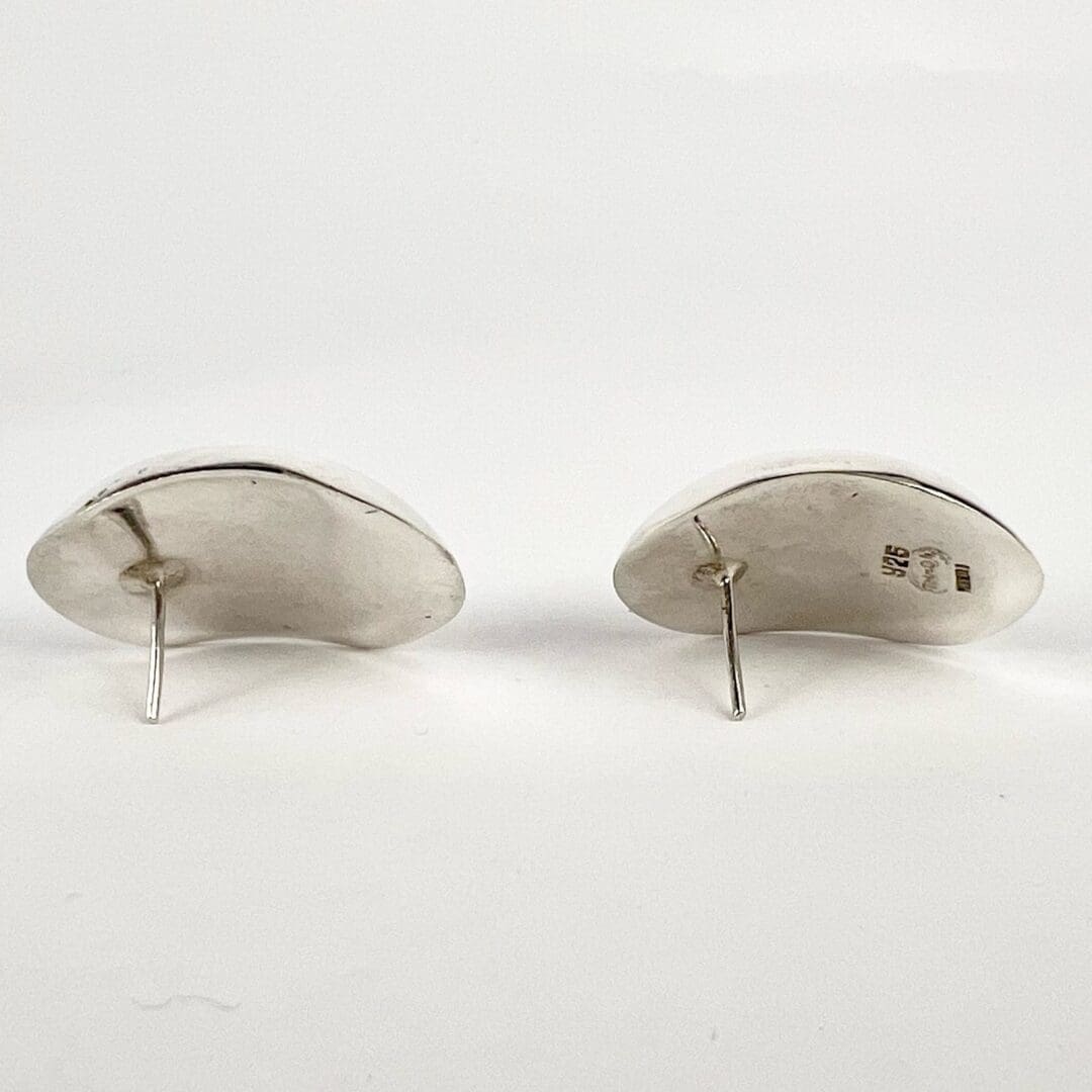 Silver earrings with posts on display.
