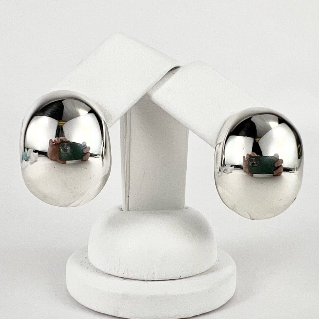 Two reflective metal spheres on white stand.