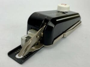 Vintage sewing machine attachment, black and silver.