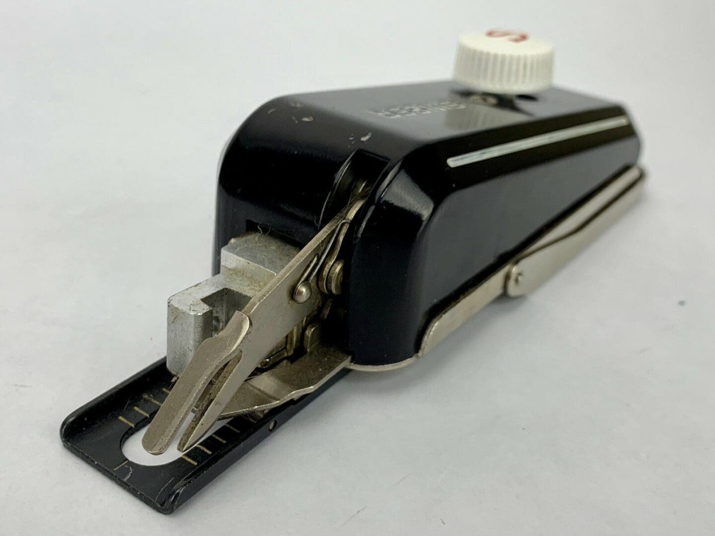 Vintage sewing machine attachment, black and silver.
