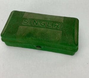 Green vintage Singer box on white background.