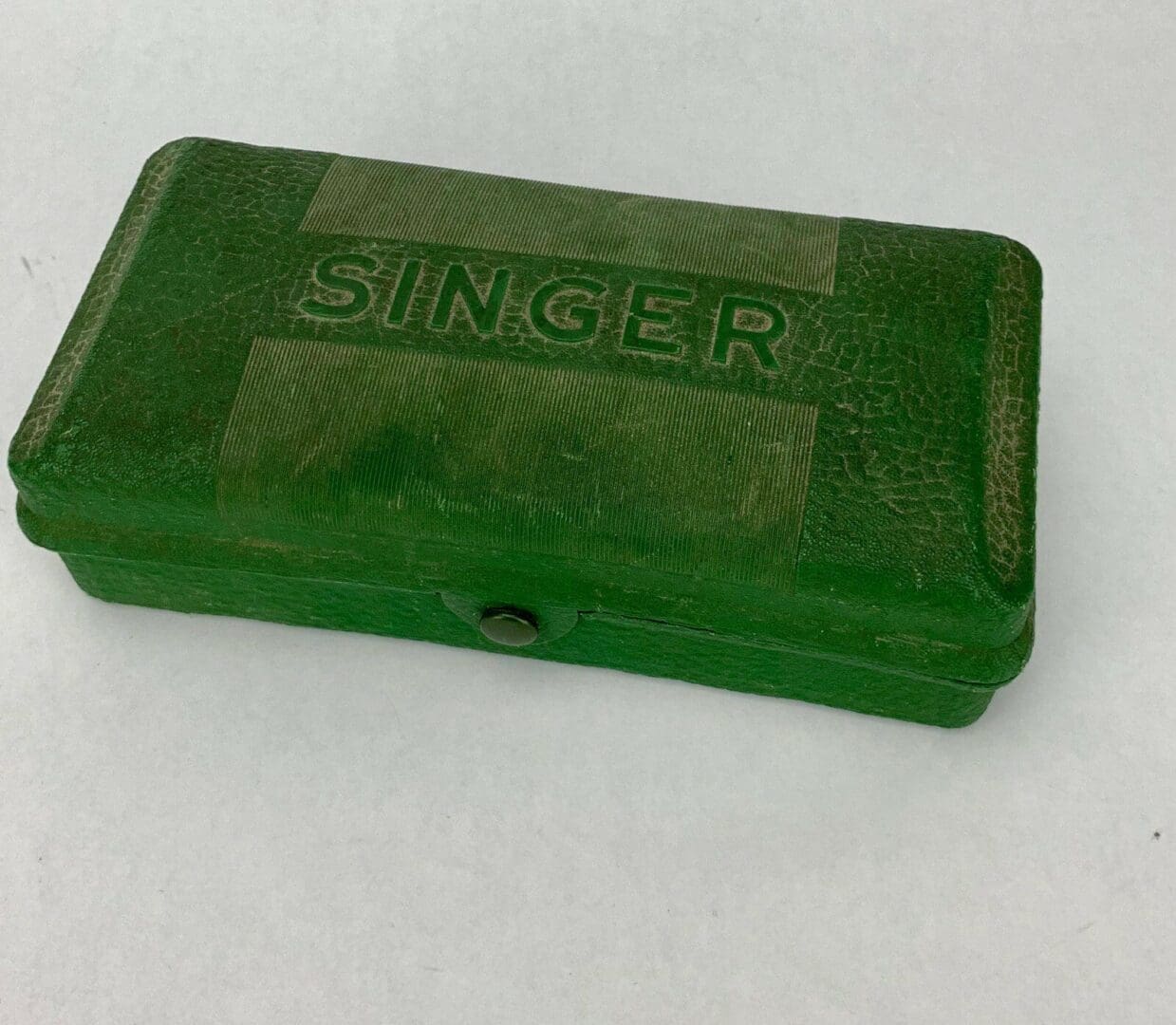 Green vintage Singer box on white background.
