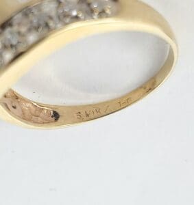 Gold ring with engraved markings inside band.