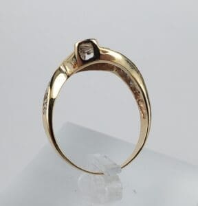 Gold ring with square gemstone on display.