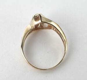 Gold ring with square gemstone setting.
