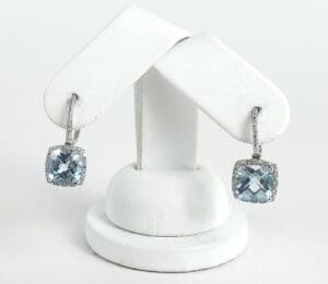 Silver earrings with blue gemstone pendants.